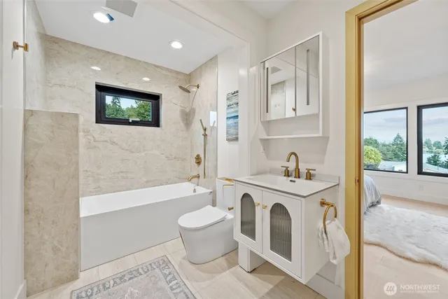 a spacious bathroom with a bathtub sink mirror and toilet