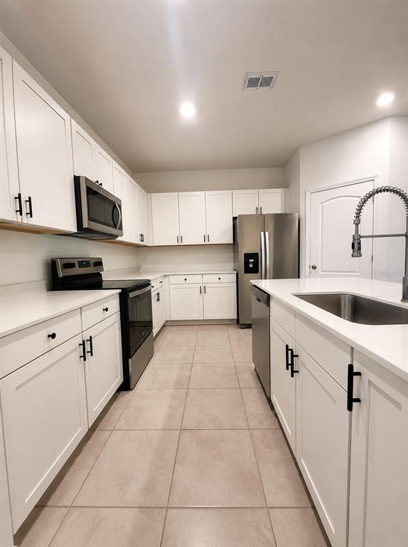 339 Redbud Road Palm Coast, FL 32137 - Photo 7 of 22 a large kitchen with stainless steel appliances granite countertop a sink and cabinets