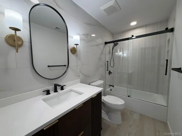 a bathroom with a sink a toilet and shower