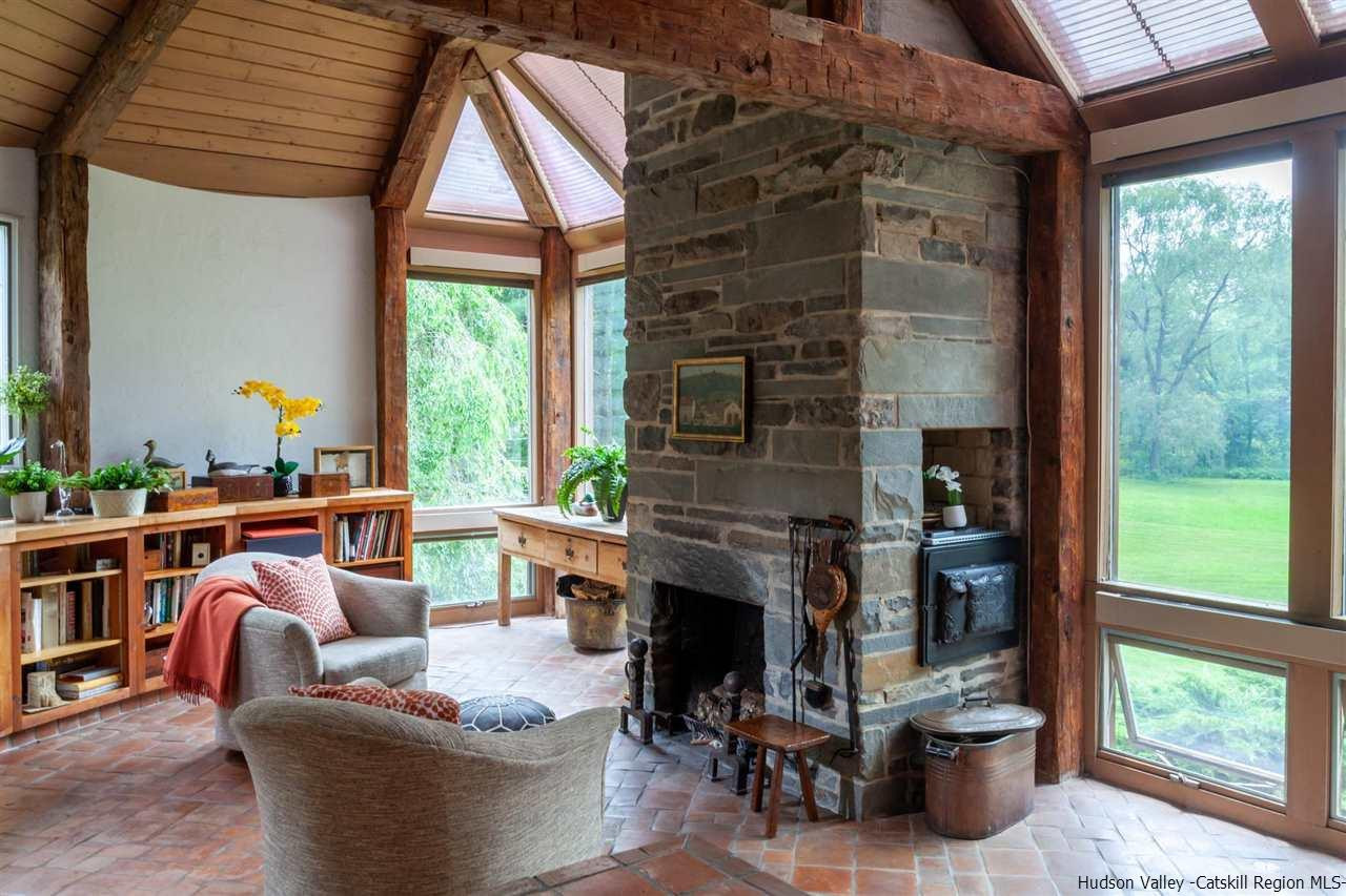 347 Old Powdermill Road Saugerties, NY 12477 - Photo 18 of 35 a living room with furniture a fireplace and a floor to ceiling window