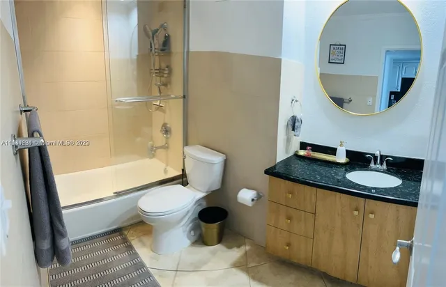 a bathroom with a granite countertop toilet a sink and a mirror
