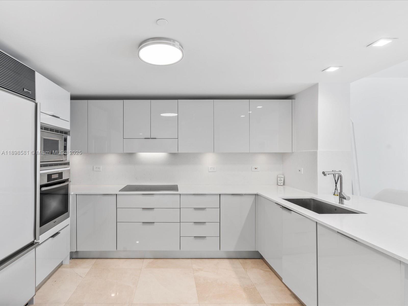 6801 Collins Avenue, Unit 1402 Miami Beach, FL 33141 - Photo 20 of 50 a kitchen with cabinets and stainless steel appliances