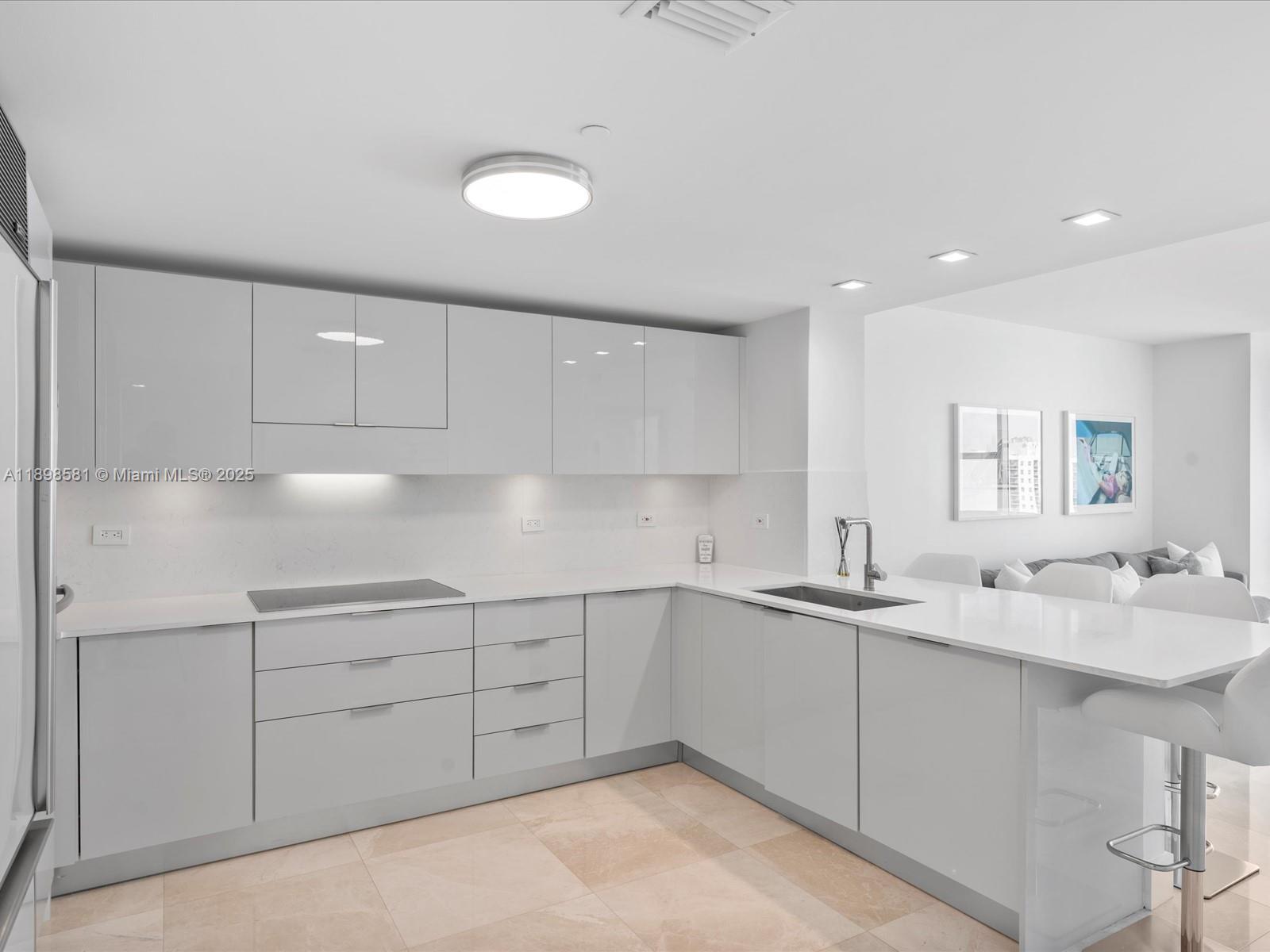 6801 Collins Avenue, Unit 1402 Miami Beach, FL 33141 - Photo 21 of 50 a kitchen with a sink and cabinets