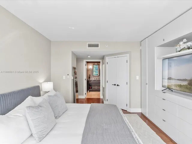 a bedroom with a large bed and chandelier