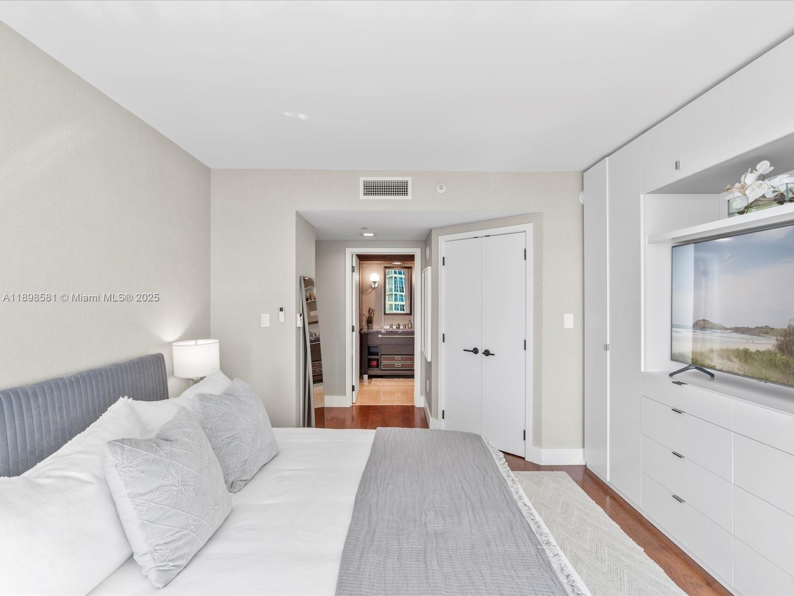 6801 Collins Avenue, Unit 1402 Miami Beach, FL 33141 - Photo 26 of 50 a bedroom with a large bed and chandelier