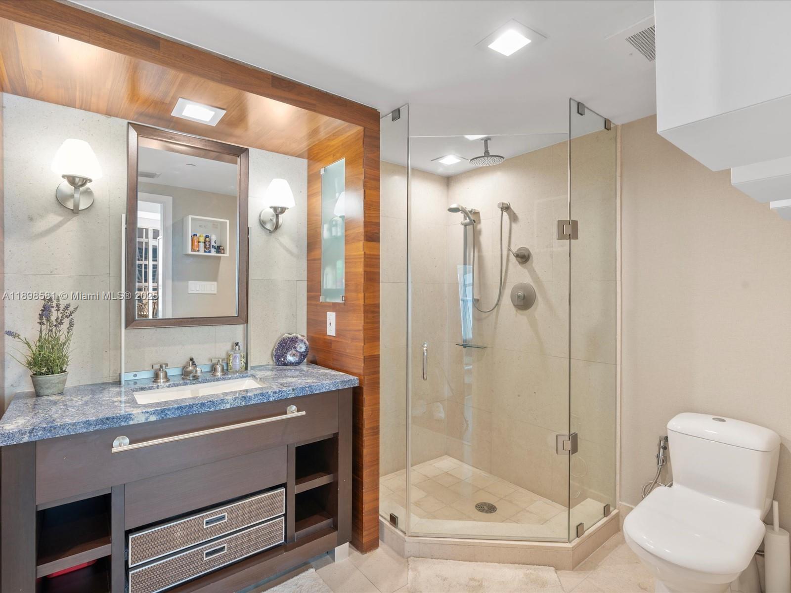 6801 Collins Avenue, Unit 1402 Miami Beach, FL 33141 - Photo 30 of 50 a bathroom with a granite countertop sink mirror shower and toilet