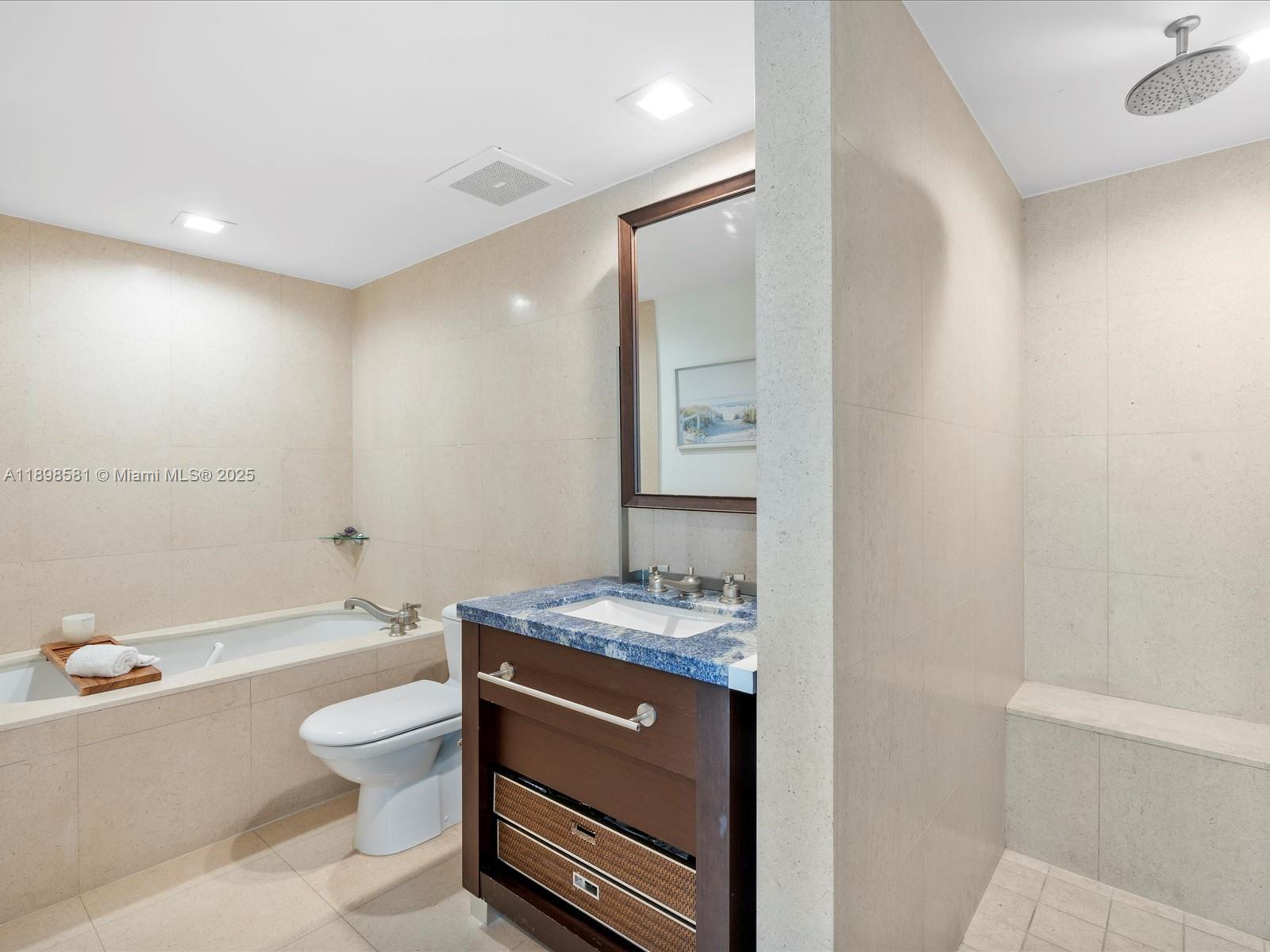 6801 Collins Avenue, Unit 1402 Miami Beach, FL 33141 - Photo 34 of 50 a bathroom with a granite countertop sink a toilet and bathtub