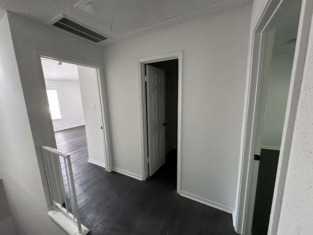 a view of a hallway with wooden floor
