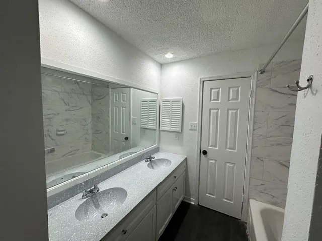 a bathroom with a double vanity sink mirror and shower