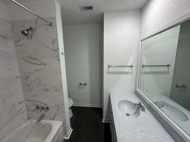 a bathroom with a tub a sink and a shower