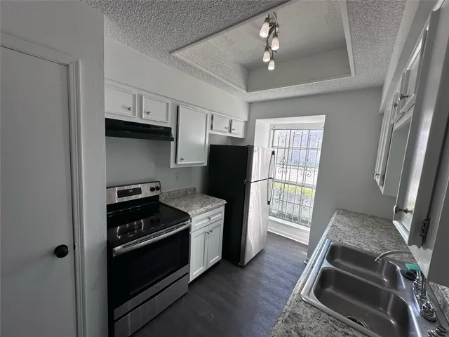 a kitchen with stainless steel appliances granite countertop a stove and a refrigerator