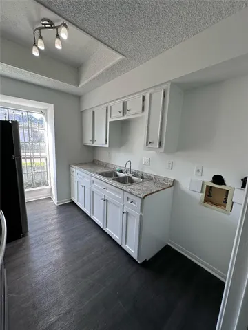 a kitchen with a sink refrigerator and window