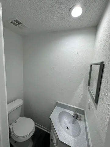 a bathroom with a toilet sink and mirror