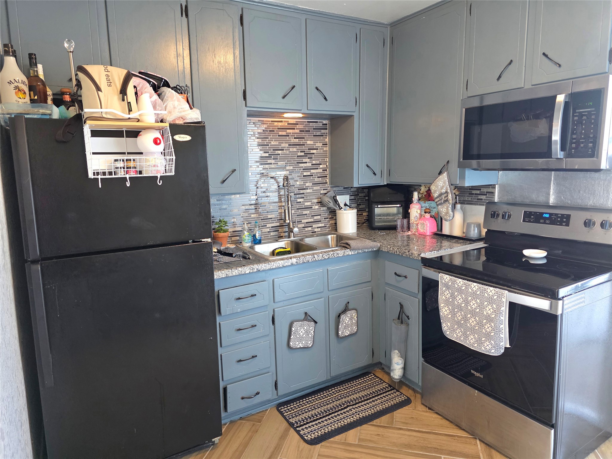 805 Sissom Road Killeen, TX 76541 - Photo 29 of 35 Kitchen featuring stainless steel appliances, parquet floors, light countertops, backsplash, and gray cabinetry