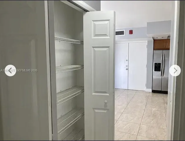 a view of a kitchen with a refrigerator and cabinet