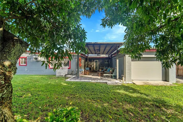 a view of a chair and tables in the back yard of the house