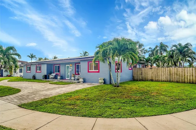 a front view of a house with a yard and trees