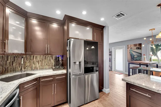 a kitchen with stainless steel appliances granite countertop a refrigerator and a sink