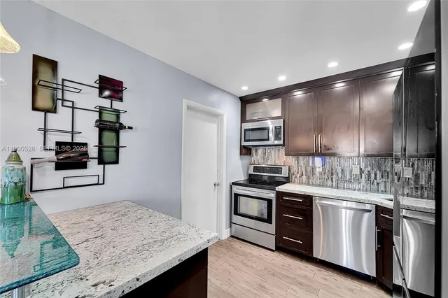 a kitchen with stainless steel appliances granite countertop a stove and a sink