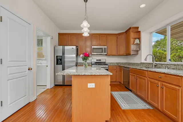 a kitchen with stainless steel appliances granite countertop a sink refrigerator and microwave