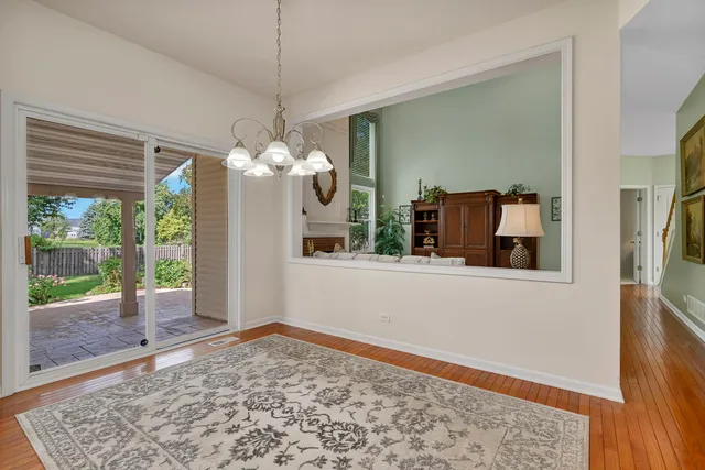 a dining room with furniture a chandelier and wooden floor