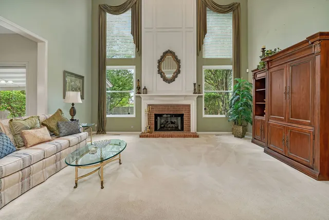 a living room with furniture a fireplace and a large window