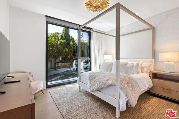 a bedroom with a bed and a large window