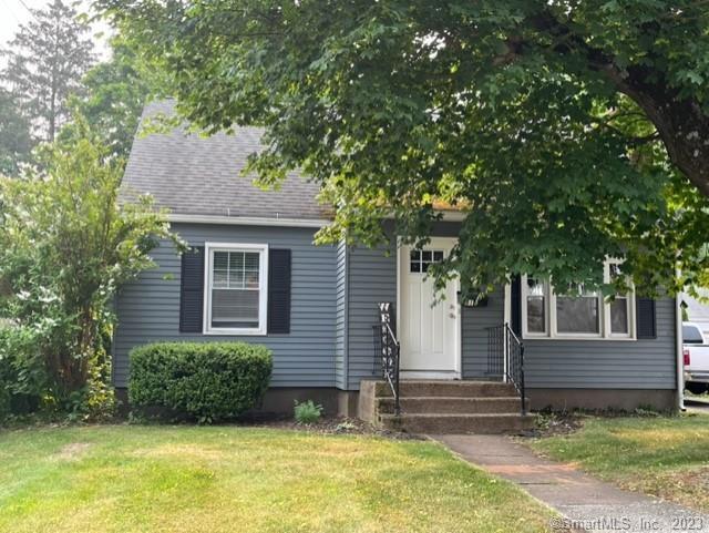 a view of house with backyard garden and tree
