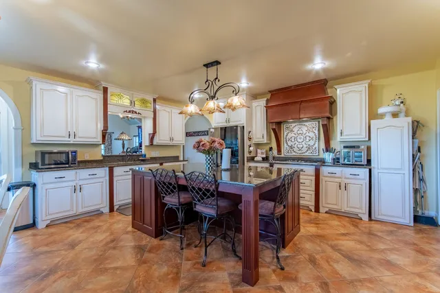 a kitchen with refrigerator cabinets dining table and chairs