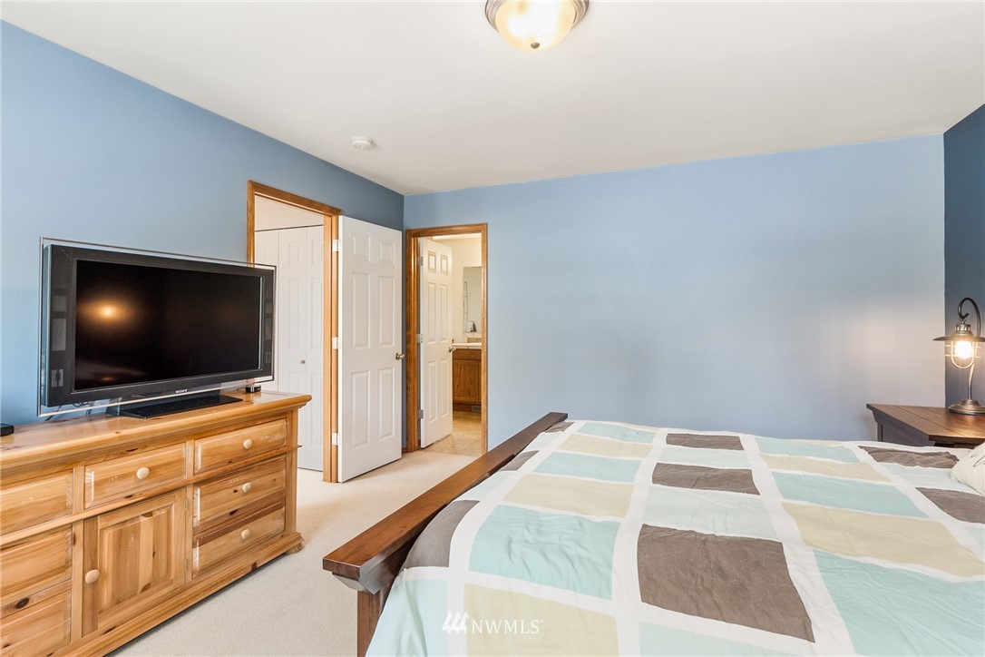 16008 Sunset Road Bothell, WA 98012 - Photo 15 of 28 a bedroom with a bed and a flat screen tv