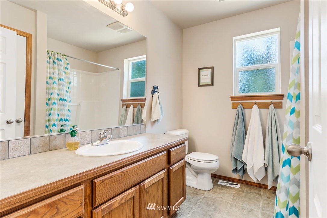 16008 Sunset Road Bothell, WA 98012 - Photo 23 of 28 a bathroom with a sink a toilet a window and a mirror