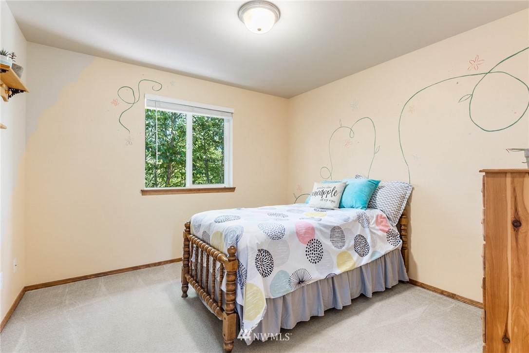 16008 Sunset Road Bothell, WA 98012 - Photo 24 of 28 a bedroom with a bed table and a window