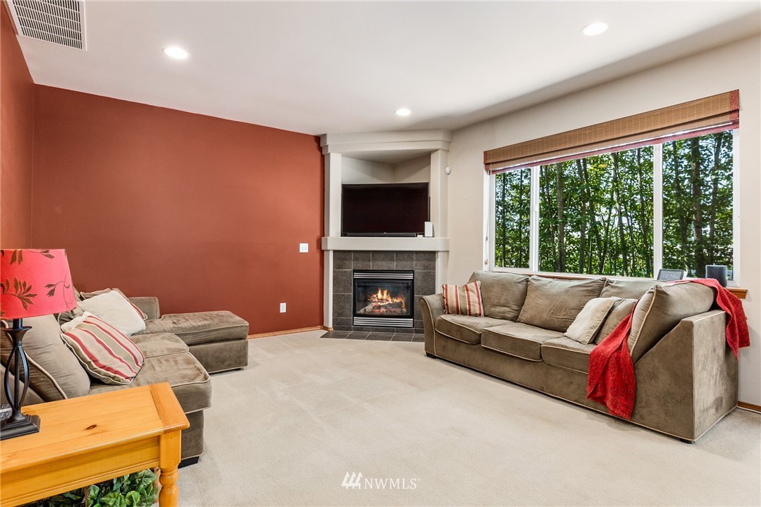 16008 Sunset Road Bothell, WA 98012 - Photo 4 of 28 a living room with furniture a large window and a fireplace