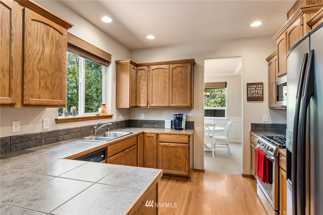 16008 Sunset Road Bothell, WA 98012 - Photo 7 of 28 a kitchen that has a sink stainless steel appliances a window and a counter top space