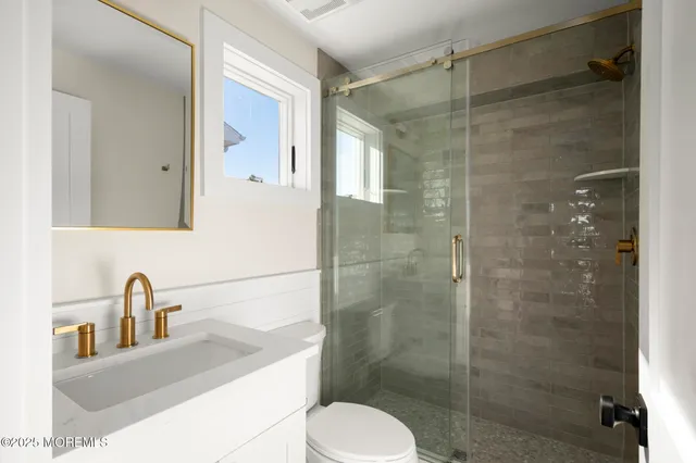 a bathroom with a sink a toilet and shower