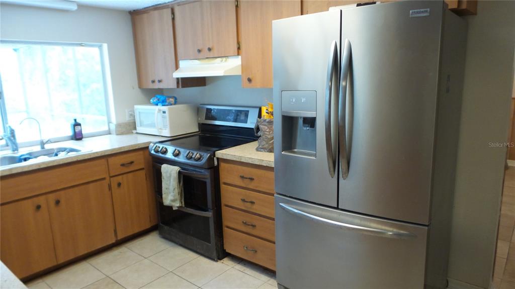 10127 Fox Squirrel Drive New Port Richey, FL 34654 - Photo 11 of 18 a kitchen with stainless steel appliances granite countertop a refrigerator sink and stove