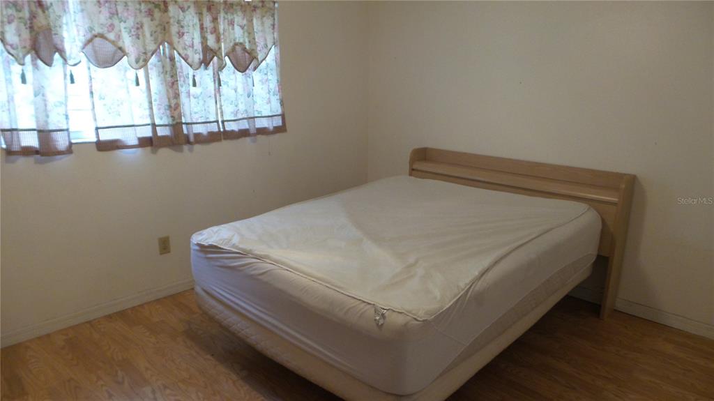 10127 Fox Squirrel Drive New Port Richey, FL 34654 - Photo 10 of 18 a bed sitting in a bedroom next to a window