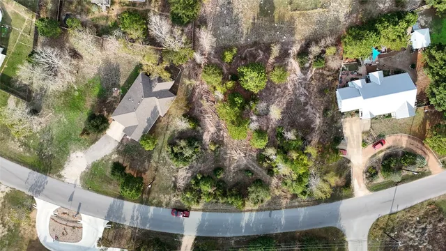 an aerial view of residential house with outdoor space and trees all around
