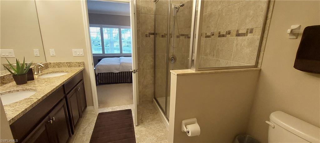 8561 Violeta Street, Unit 202 Estero, FL 34135 - Photo 18 of 40 a en suite bathroom with a granite countertop sink and a mirror