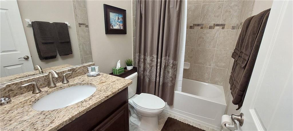 8561 Violeta Street, Unit 202 Estero, FL 34135 - Photo 22 of 40 a bathroom with a granite countertop sink toilet and shower a mirror