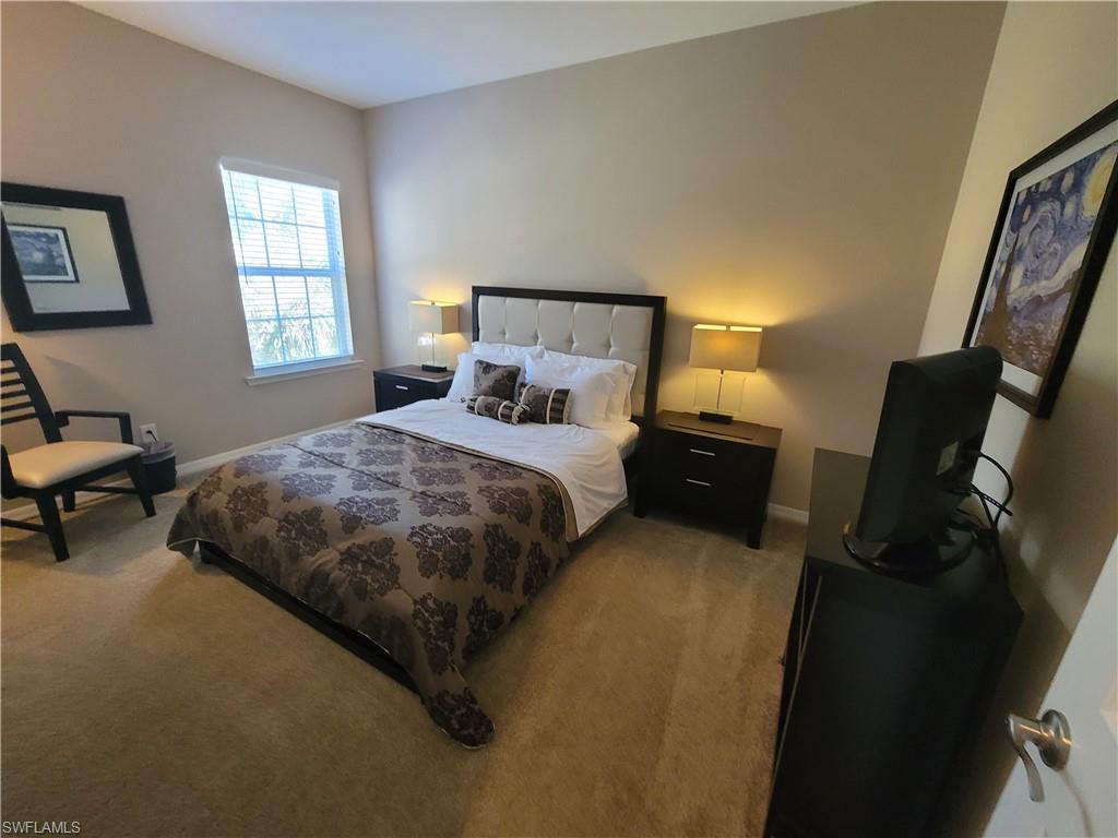 8561 Violeta Street, Unit 202 Estero, FL 34135 - Photo 23 of 40 a bedroom with a bed and wooden floor