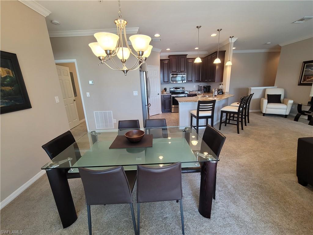 8561 Violeta Street, Unit 202 Estero, FL 34135 - Photo 9 of 40 a view of a dining room with furniture and a chandelier