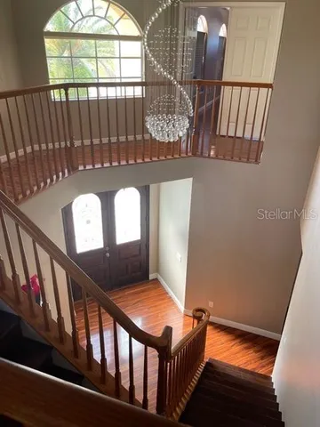 a view of staircase with a black white wall clock and a window
