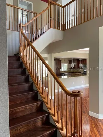 a view of staircase with lots of frames on wall and wooden floor
