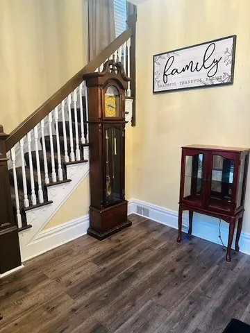 a view of a hallway with wooden floor and stairs