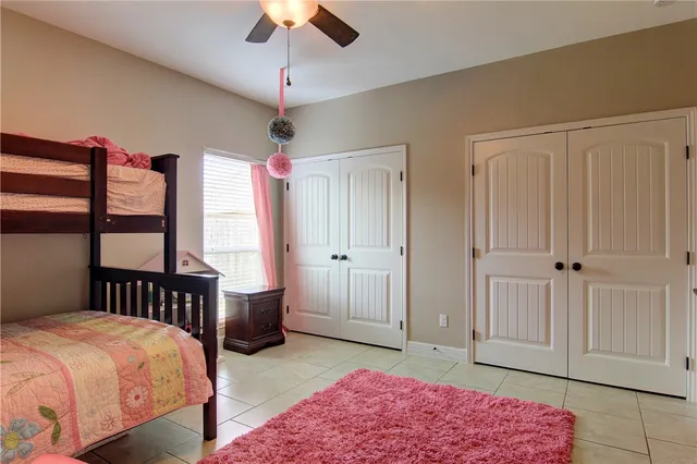 a bedroom with a bed a window and potted plant