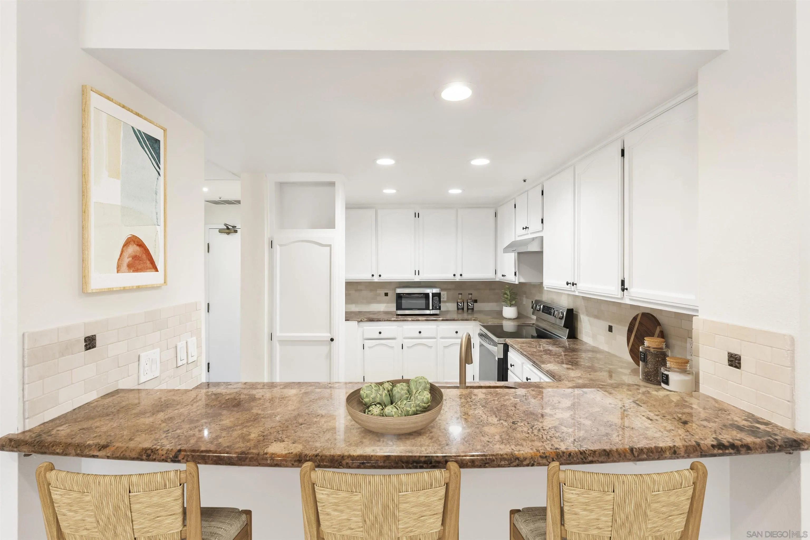 5805 Friars Road, Unit 2115 San Diego, CA 92110 - Photo 4 of 16 a kitchen with granite countertop a sink and white cabinets