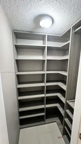 a view of walk in closet with empty racks