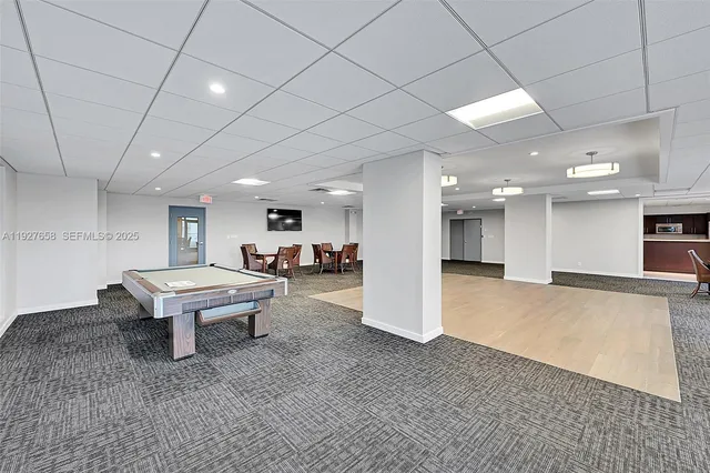 a living room with furniture a table tennis pool table and chairs