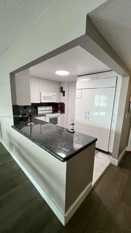 a kitchen with stainless steel appliances granite countertop a sink and a stove